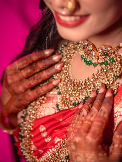 A detail shot of a Marathi bride's intricate necklace and henna-adorned hands. Capturing these elements is key to telling the full story of her bridal look.