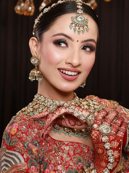 A beautiful candid shot of a bride, her smile and her mehandi-adorned hands creating a picture of pure happiness.