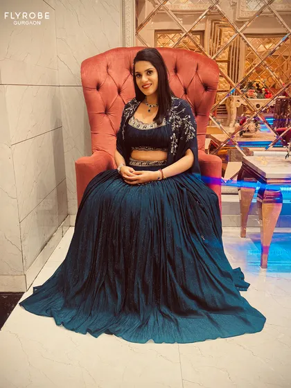 Feel like royalty in this deep blue pleated lehenga. The embroidered cape and waistband add a touch of glamour, perfect for an evening reception.
