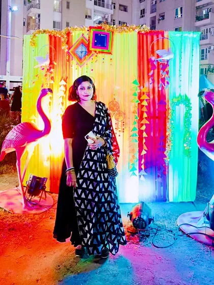 Celebrating Dussehra in a black anarkali with a geometric print dupatta. The vibrant, colorful background makes the outfit stand out.