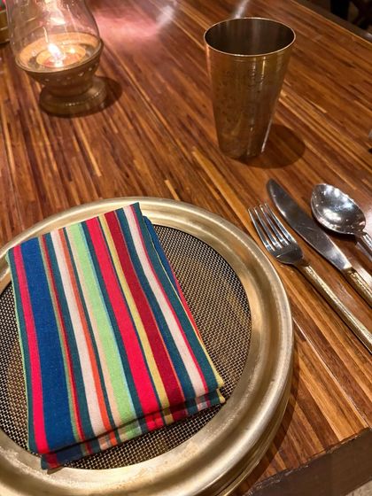 The small details make the meal. A colorful striped napkin and brass tableware at Loya, Taj Palace, show the restaurant's commitment to a luxurious, traditional North Indian dining experience.