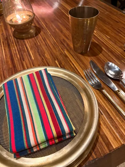 The vibrant table setting at Loya. The colorful napkin against the traditional brass thali speaks to the restaurant's blend of modern and heritage aesthetics, a detail I knew my audience would appreciate.