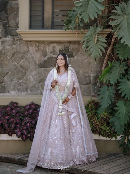 A stunning full-length portrait of the bride in her beautiful white lehenga, capturing her grace and elegance on her wedding day.