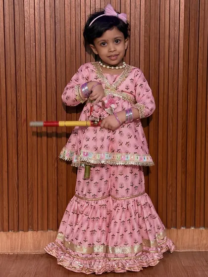 This little one is ready for Dandiya in her pretty pink sharara set. Our classes are open to kids of all ages, helping them connect with cultural traditions from a young age.