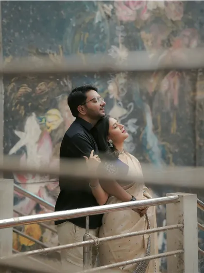 A beautifully framed shot of the couple against a mural, viewed through a railing. I always look for unique angles and compositions to make your photos stand out.