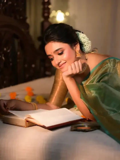 A romantic and literary-themed shot of a model reading a book in bed. The soft, warm lighting and classic setting evoke a sense of nostalgia and quiet contemplation.