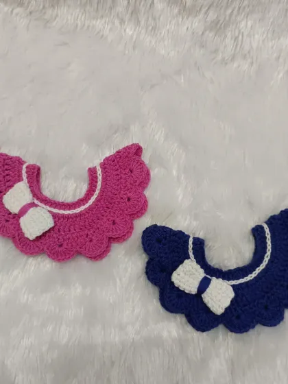 Here are two of my detachable baby collars in bright pink and royal blue, each with a cute little bow. I make them from soft cotton yarn so they are comfortable for your little one to wear all day.