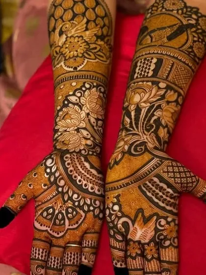 A dense, full-coverage mehendi with a mix of floral and peacock motifs. The use of dark and light henna creates a beautiful contrast.