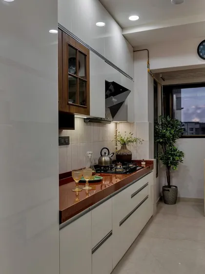 As Julia Child said, ‘The kitchen is the heart of the home.’ This space, with its warm red countertop, white cabinets, and a touch of greenery, is designed to be both joyful and functional.
