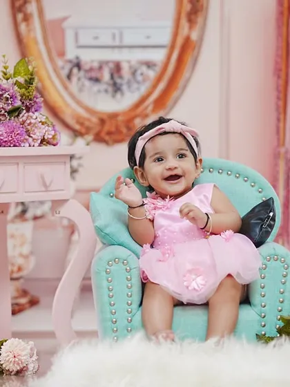 Six months of sweetness. This little girl is celebrating her half-birthday in a glamorous pink closet setup, looking like a little fashionista.