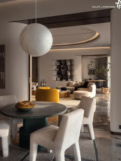 A view from a small dining nook into the magnificent living room of the Palais Royale apartment. The design embraces quiet luxury, where every detail is curated to evoke calm, depth, and effortless elegance against panoramic views of the Arabian Sea.