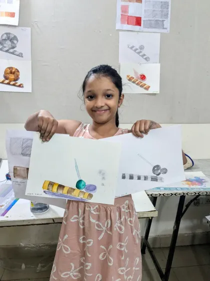 So much progress in one class! This student is happy to show her pencil and watercolor studies of a lollipop and wafer, mastering both line work and color.