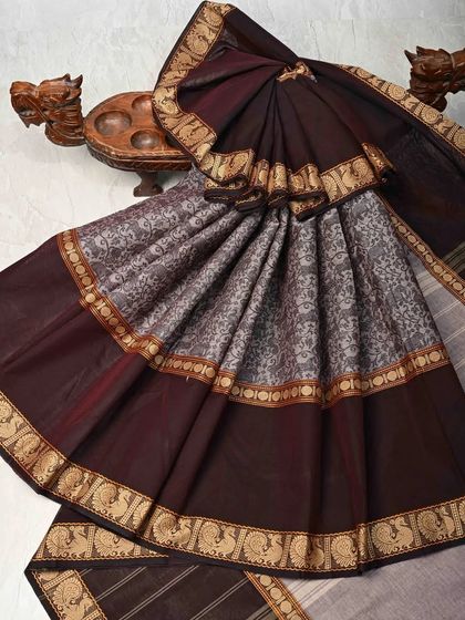 A beautiful cotton saree in a deep maroon and grey combination. The body features a traditional block print, and the peacock motif border adds a classic touch.