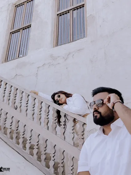 A cool, relaxed pose on a staircase with interesting architectural details. This shot highlights a casual yet chic pre-wedding photography style.