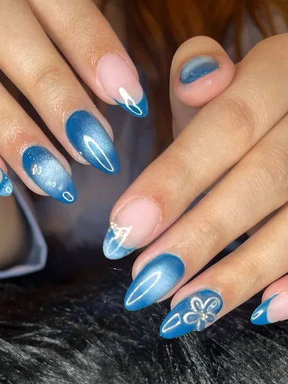 A beautiful blue aura nail set with cat eye effects and silver chrome accents.