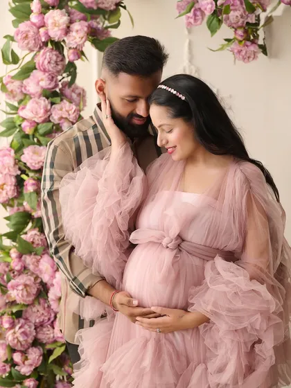 We believe maternity photos should be as magical as the life you're creating. In this fine-art maternity portrait, we used a cascade of pink peonies and a flowing tulle gown to create a dreamy, romantic atmosphere for the expecting couple.