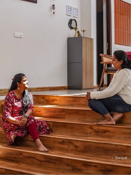 The wide wooden stairs are bathed in sunlight, inviting movement and pause. They function as both circulation and a place to sit and gather.