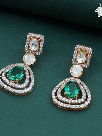 The Green Grace earrings, perfectly complementing the necklace. Each earring features a triangular arrangement of emeralds and diamonds, reflecting the design of the main pendant.