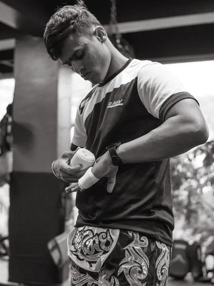 A fighter carefully wraps his hands, a crucial step to protect the knuckles and wrists before throwing punches.