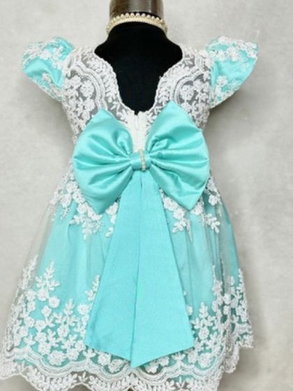 A stunning aqua version of our "Arya" dress. The oversized bow at the back adds a touch of drama and fun to this beautifully detailed lace party dress.