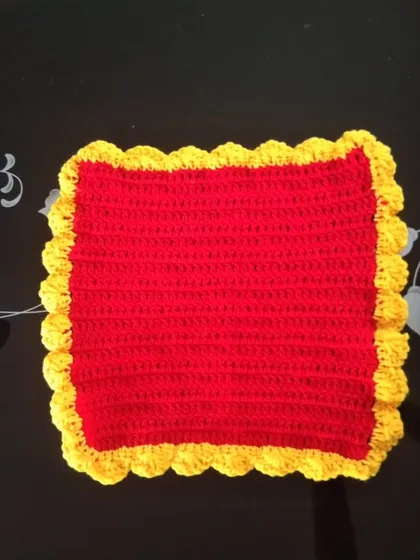 A square table mat in red and yellow.