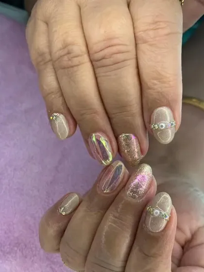 A chic and elegant set with a neutral base, accented with gold glitter and iridescent chrome nails.
