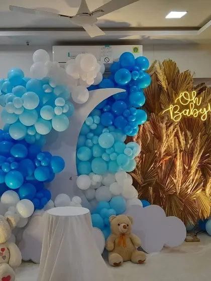 An "Oh Baby" celebration with a "Twinkle Twinkle Little Star" vibe. The blue and white balloons are arranged around a crescent moon, with teddy bears and fluffy clouds completing the scene.