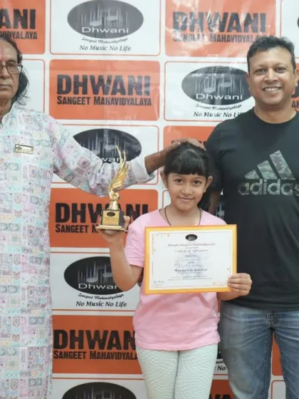 A student, her father, and our senior guru celebrating her achievement.