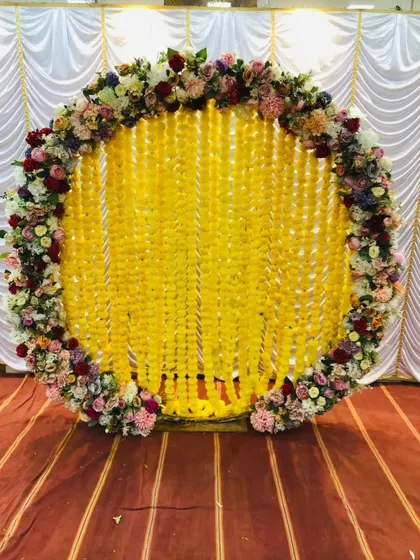 This grand backdrop combines the tradition of marigold strings with a lush, colorful border of mixed fresh flowers for a stunning effect.