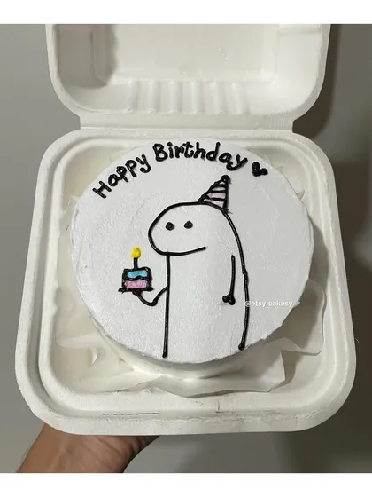 A simple and cute birthday bento cake featuring a popular stick-figure character wearing a party hat and holding a tiny cake.