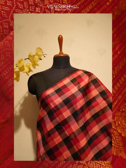 A bold and modern take on tradition, this Kanjivaram features a large-scale check pattern in shades of red, peach, and black.