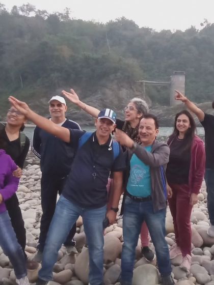 A happy group of participants enjoying the scenic beauty by the river during the Ultimate Survival Camp getaway.