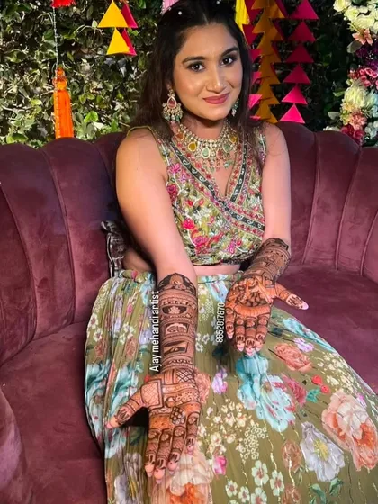 A smiling client showing her beautiful mehndi design during her celebration.