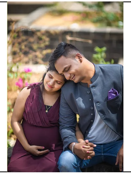 A tender moment of rest, with the mom-to-be leaning her head on her partner's shoulder.
