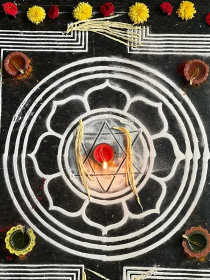 A sacred mandala drawn for the yajna, with a diya at its center. This represents the cosmos and the divine light within. Rituals like these are a way to connect with the deeper patterns of the universe.