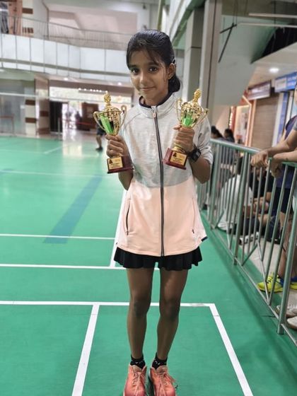 Swati showing off her two trophies after winning both the U-13 and U-15 categories at the Racket Rider Tournament. A remarkable achievement that showcases her talent and stamina.