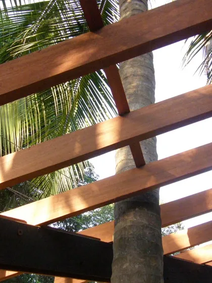A palm tree is carefully integrated into the structure of K-Lagoon. The wooden beams of the pergola are notched to accommodate the trunk, a small but significant detail that shows our respect for the existing nature.