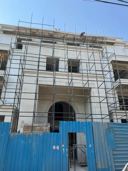The facade of a new residential project is seen here covered in scaffolding. This stage is critical for executing the intricate details of the exterior, ensuring every element aligns with our design intent before the final reveal.