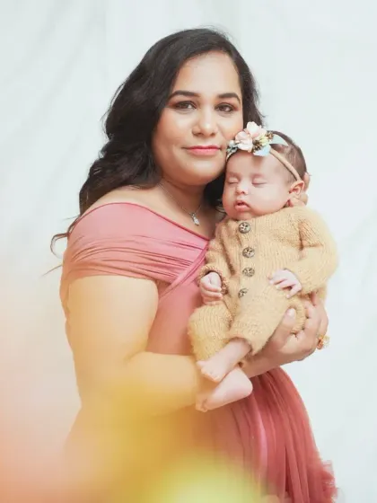 A mother holds her newborn baby close in this tender portrait. We use soft lighting to create a warm and gentle atmosphere for newborn sessions.