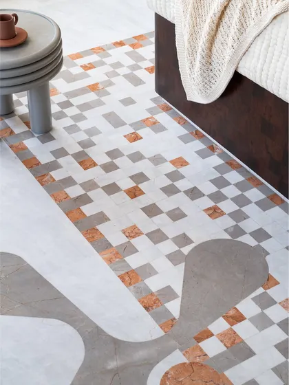 We love adding playful details where you least expect them. This burlwood media unit is grounded by pixel-like marble blocks, a detail that connects it to the geometric marble inlay on the floor, creating a cohesive design story.