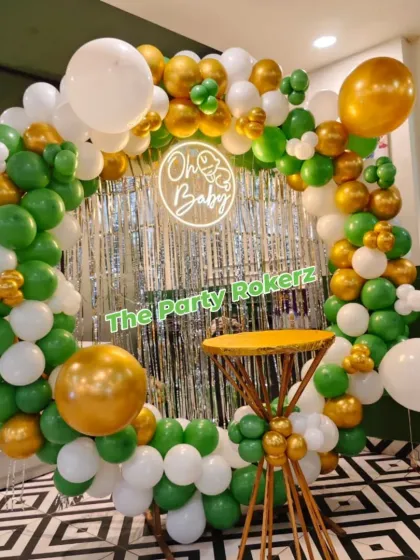 The full circular balloon backdrop for the green and gold "Oh Baby" shower, providing a fresh and modern look for the celebration.
