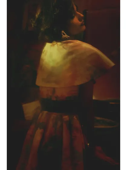 From 'Chapter 3: Hall of Longing'. The styling introduces a new silhouette with a cape-like top, suggesting a shift in the character's journey. The lighting is shadowy and mysterious.