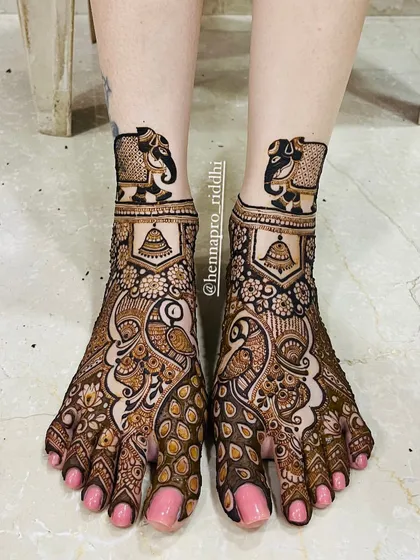 Don't forget the feet! A full traditional foot design with peacocks and elephants adds a regal touch to your complete bridal look. The details here are just as important as the hands.