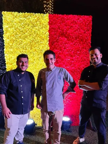 Our core team, Chef Goldy, Chef Christophe, and Manager Chetan, in front of a floral wall of the Belgian flag. This team is the driving force behind our ability to execute large, flawless events.