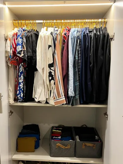 A wardrobe that is both organized and easy on the eyes. This is achieved with matching hangers, color coding, and a mix of hanging and folded storage.