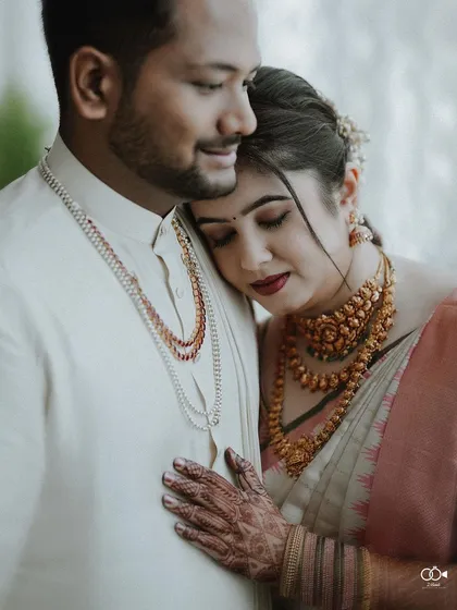 A quiet, intimate portrait from a traditional wedding day. The bride rests her head on her groom's shoulder, a simple gesture that speaks volumes about their comfort and deep connection.