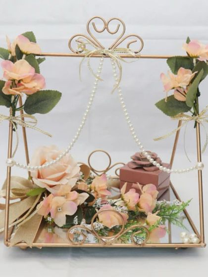 For a truly romantic and whimsical ring ceremony, I designed this swing-style platter. The rings are placed on a mirrored base, adorned with delicate pearls and soft peach roses.