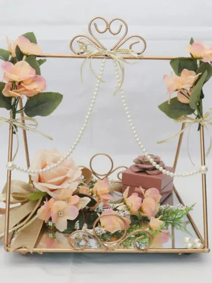 For a truly romantic and whimsical ring ceremony, I designed this swing-style platter. The rings are placed on a mirrored base, adorned with delicate pearls and soft peach roses.