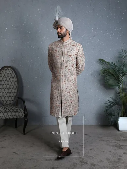 A full-length view of the coffee-beige sherwani, showing its structured silhouette and how it pairs with classic churidar pants, embodying modern royalty.