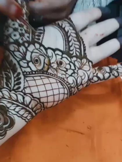 A close up of a fresh henna application. You can see the precision in the floral and leaf patterns, with fine netting work that adds a delicate touch to the design.